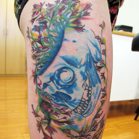 Colorful watercolor tattoo with skull and plants